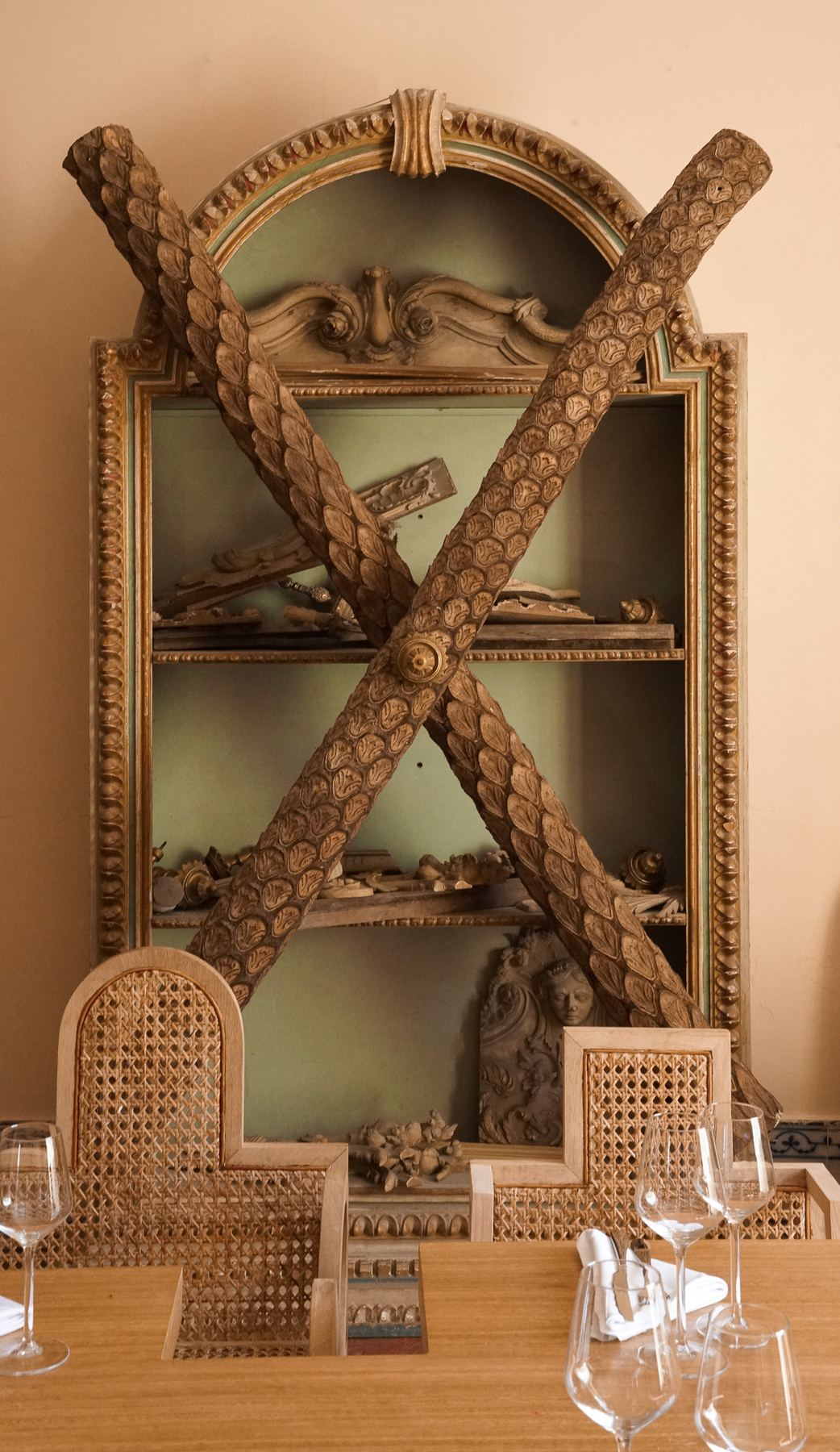Detalhe da decoração barroca do Palácio do Grilo em Lisboa, com um armário adornado por elementos de madeira. Um ambiente único.