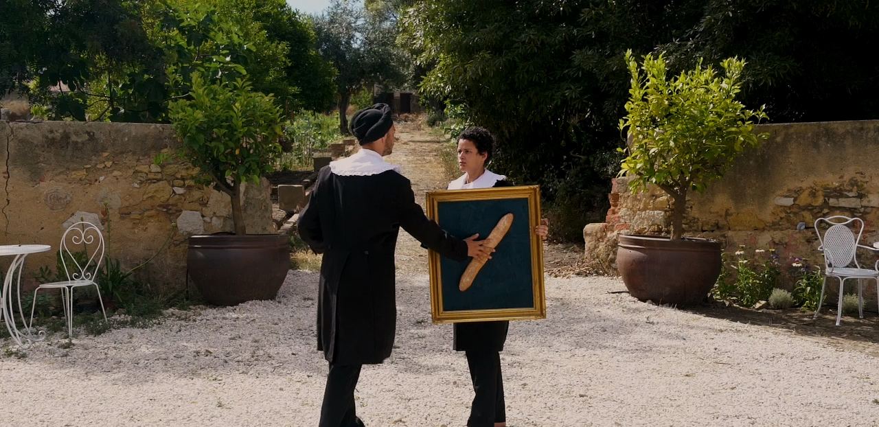 Dois personagens barrocos trocam uma pintura de baguete no pátio do Palácio do Grilo, Lisboa, sob luz natural.