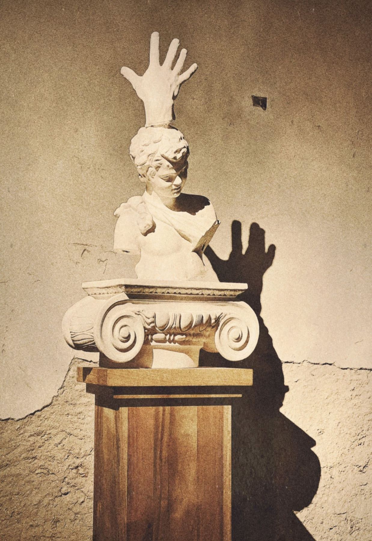 Um busto clássico com uma mão levantada no topo, em uma base de madeira no Palácio do Grilo em Lisboa.