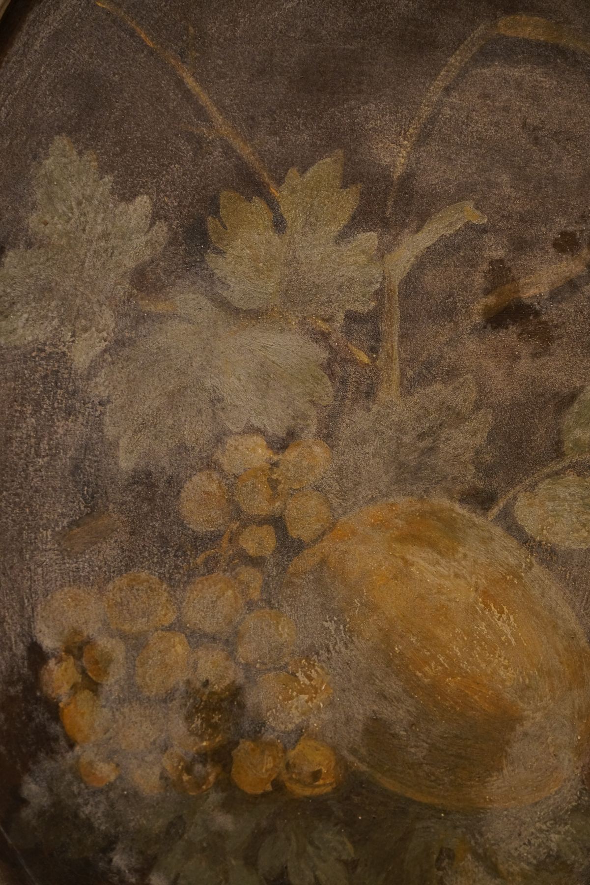 Detalhe de pintura mural antiga no Palácio do Grilo, retratando uvas, folhas e um melão em Lisboa.
