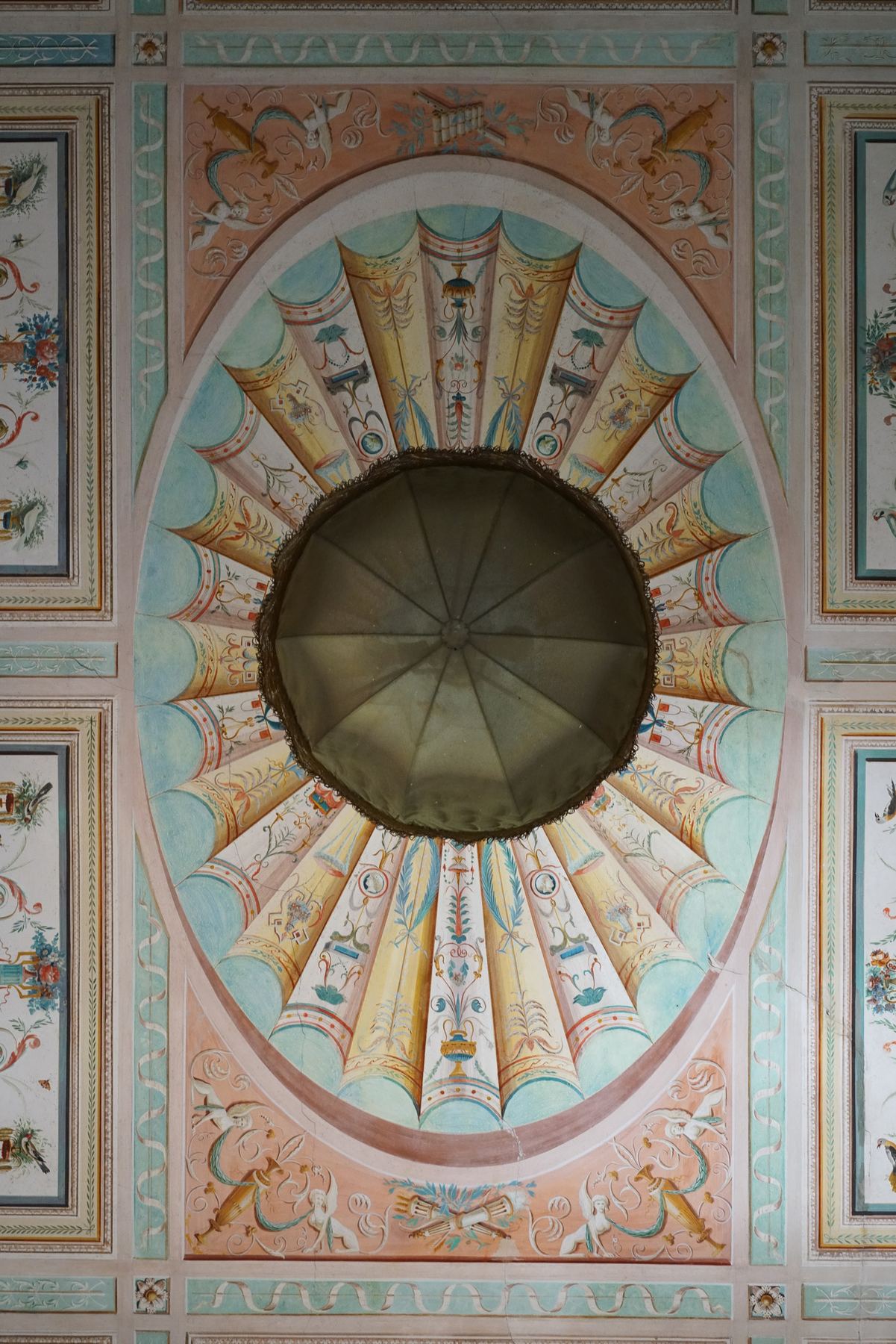 Teto oval pintado no Palácio do Grilo em Lisboa, exibindo motivos barrocos coloridos em tons pastel, com uma cúpula central de tecido.
